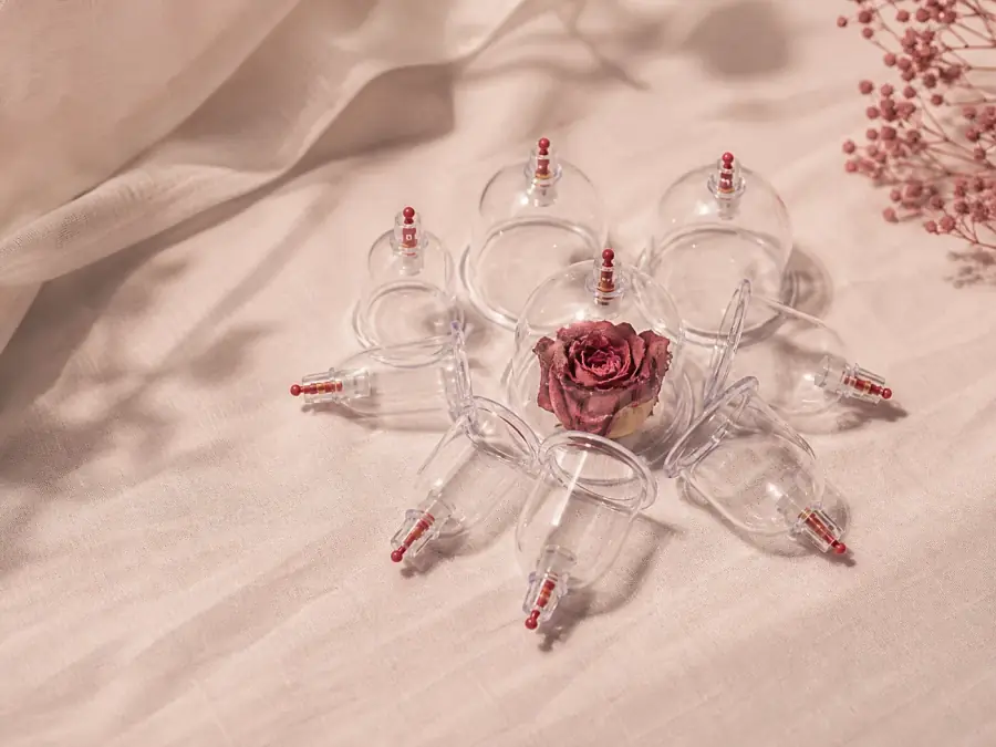 Coppette terapeutiche disposte su un tessuto rosa in un ambiente tranquillo